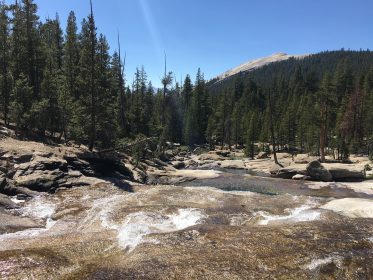 kayaking photo of tenaya creek with yosemite mountains above it