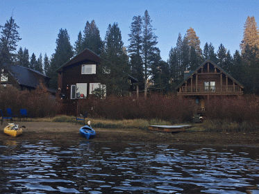 shoreline of serene lakes with houses and kayaks