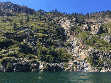 narrow waterfall flowing through exposed rocks into fallen leaf lake