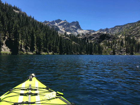 Sardine Lake in Gold Lakes, California region with kayak in bottom left foreground, sardine lake on lower half of photo, and butte peak and pine trees rising above the lake in the background